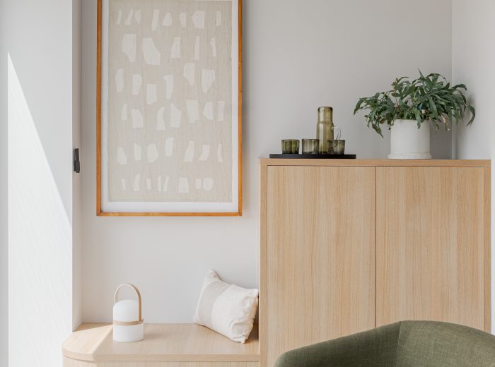 Recepción de oficina con zona de descanso en tonos neutros, beige, verde y madera de roble en proyecto AM48, Vitoria-Gasteiz