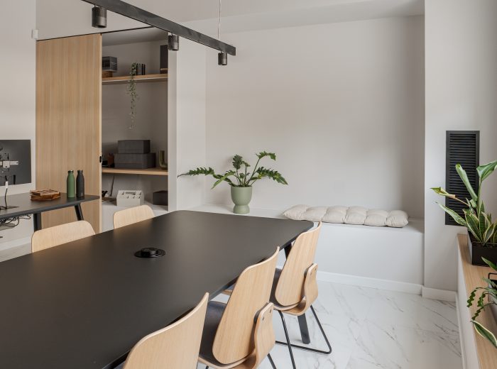 Despacho y sala de reuniones con mobiliario negro y decoración en tonos neutros en proyecto AM48, Vitoria-Gasteiz