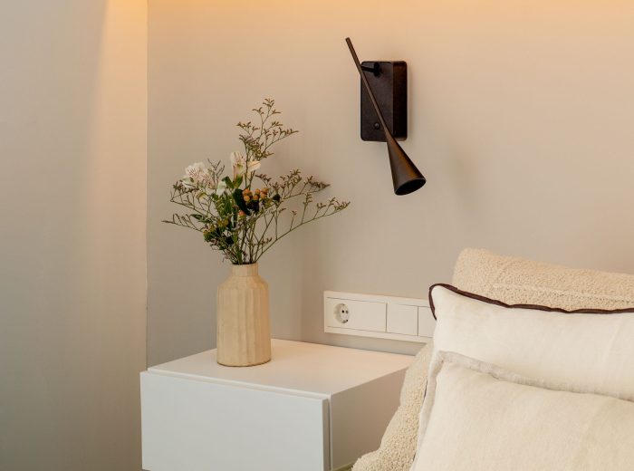 Habitación principal con mesillas blancas suspendidas y luz indirecta a modo de cabecero, reforma interior AG76, Vitoria-Gasteiz.