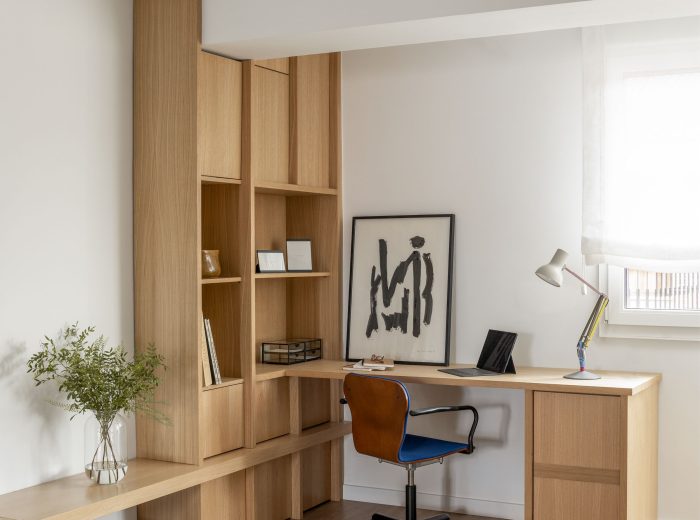 Estudio integrado en salón con estantería y bancada de madera de roble continuidad desde el recibidor, reforma interior AG76, Vitoria-Gasteiz.