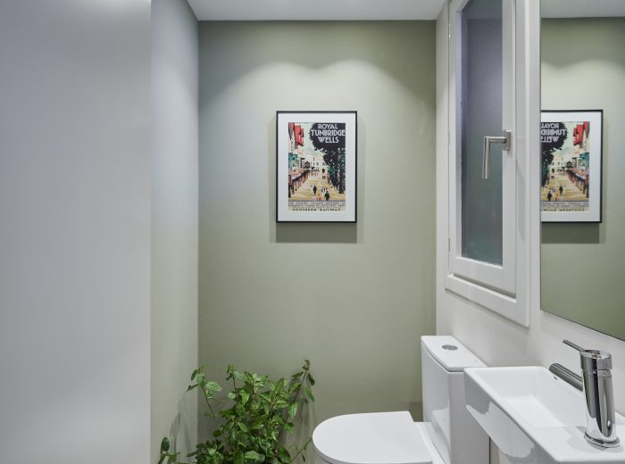 Aseo de cortesía oculto tras puerta panelada - Reforma integral, interiorismo y decoración de oe arkitektura en proyecto AM6, Vitoria-Gasteiz