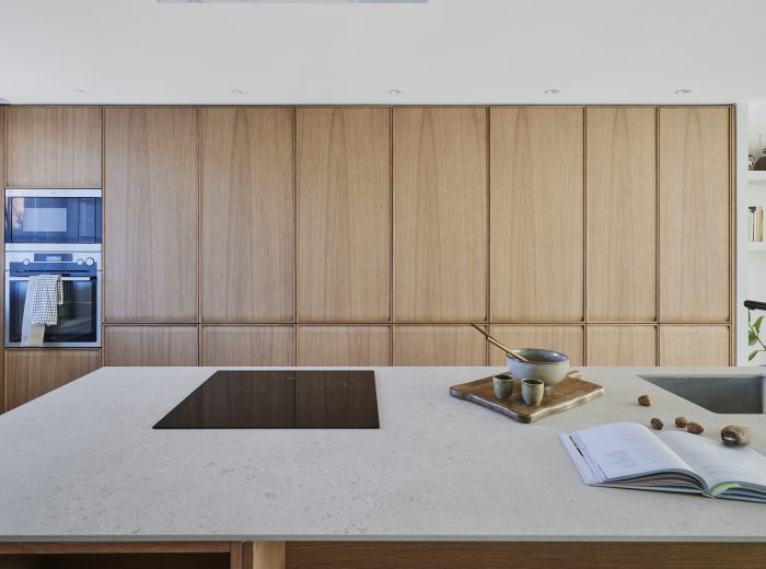 Diseño de cocina con isla central y armarios de roble - Reforma integral, interiorismo y decoración de oe arkitektura en proyecto AM6, Vitoria-Gasteiz