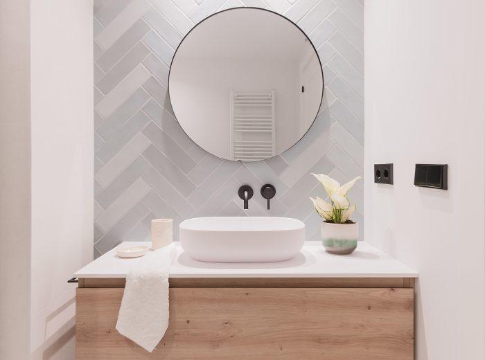 baño ensuite, mueble en madera con lavabo sobre encimera, grifería negra empotrada y azulejo espiga azul claro, reforma interior BG9, Vitoria-Gasteiz