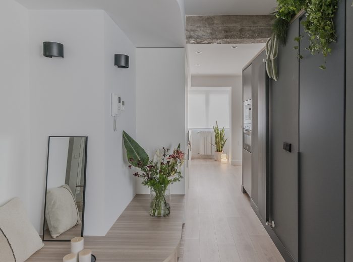 Recibidor con bancada de madera y viga hormigón vista, reforma interior BG9, Vitoria-Gasteiz