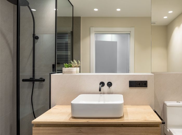 baño principal de diseño, mueble en madera con lavabo sobre encimera y grifería empotrada en negro, azulejo tonos grises, reforma interior y diseño de interiores y amueblamiento EF13, Vitoria-Gasteiz
