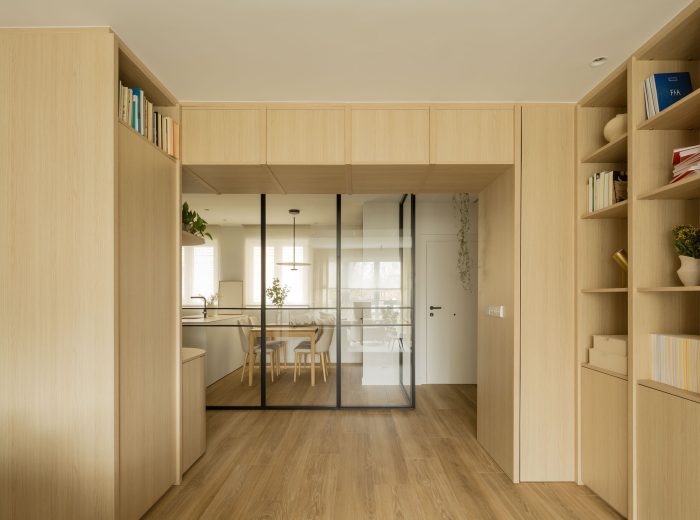 Vista del salón hacia la recepción y cocina con cerramientos acristalados correderos  en proyecto F86, Vitoria-Gasteiz