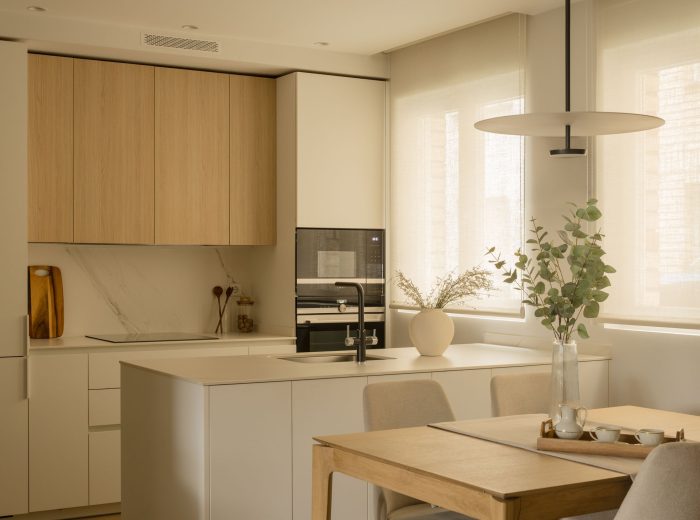 Cocina de diseño con península central en tonos neutros y madera en proyecto F86, Vitoria-Gasteiz