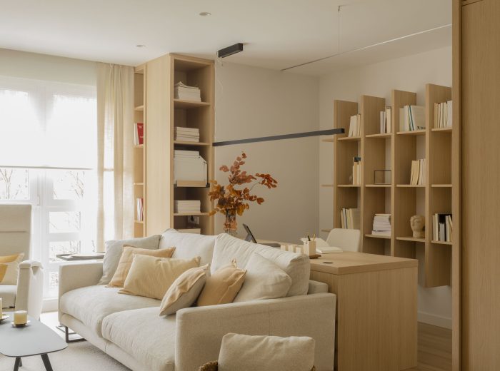 Vista del salón que incorpora un espacio de estudio funcional y estético detrás del sofá, optimizando el uso del espacio y manteniendo una decoración armoniosa  en proyecto F86, Vitoria-Gasteiz.