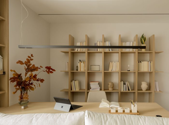 Vista del salón que incorpora un espacio de estudio funcional y estético detrás del sofá, optimizando el uso del espacio y manteniendo una decoración armoniosa en proyecto F86, Vitoria-Gasteiz.