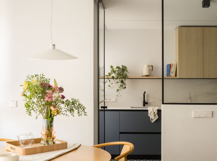 Comedor y cocina conectados visualmente mediante una cristalera para potenciar la luz natural en proyecto FL9, Vitoria-Gasteiz.