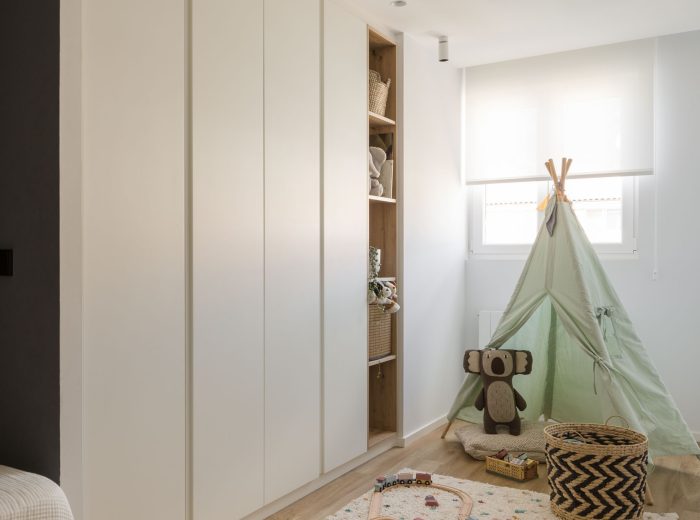 Dormitorio infantil con armario blanco a medida y zona de juegos en tonos pastel en proyecto FL9, Vitoria-Gasteiz