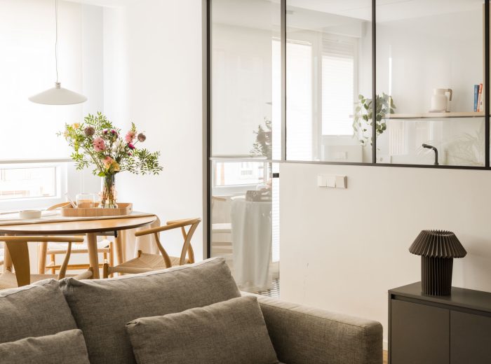 Espacio abierto que integra salón y comedor, conectado visualmente con la cocina mediante una cristalera para potenciar la luz natural en proyecto FL9, Vitoria-Gasteiz.