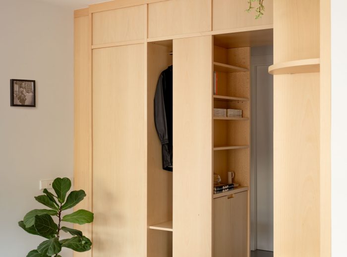 Recibidor abierto al salón mediante mueble separador a medida con almacenaje integrado, reforma integral O50 en Vitoria-Gasteiz.