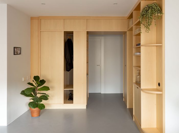 Mueble central realizado a medida en madera de haya que articula recibidor y salón, proyecto de interiorismo O50 en Vitoria-Gasteiz.