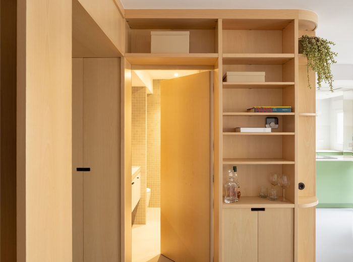 Detalle de puerta oculta integrada en mueble de madera a medida con acceso al baño, reforma O50 en Vitoria-Gasteiz.