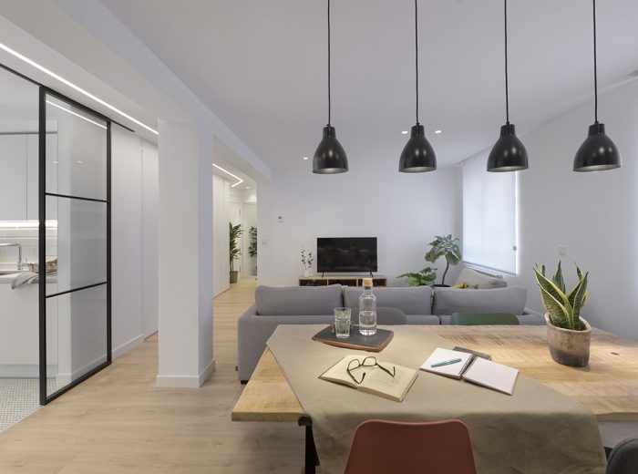 Espacio de día conectado con la cocina mediante cristalera con perfilería de aluminio negra a medida, proyecto de reforma integral RB5 en Vitoria-Gasteiz.