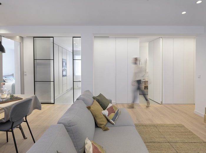 Detalle de puerta oculta integrada en mueble a medida siguiendo el ritmo del armario lacado, reforma integral RB5 en Vitoria-Gasteiz.