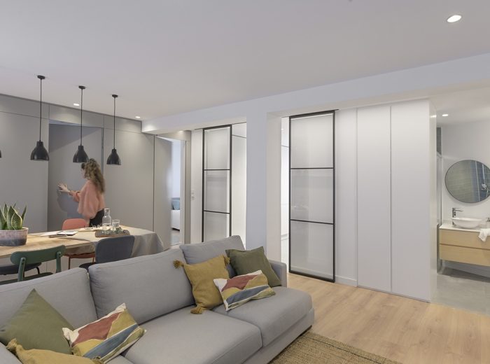 Puertas ocultas integradas en panelado lacado que conectan con la zona privada de la vivienda, reforma integral RB5 en Vitoria-Gasteiz.