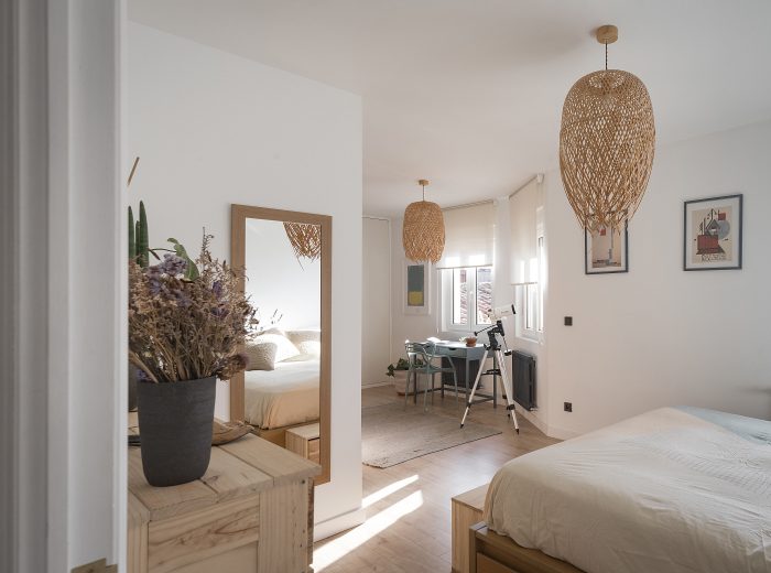 Dormitorio principal abierto con zona de descanso conectada visualmente al vestidor, reforma interior RM17 en Vitoria-Gasteiz.