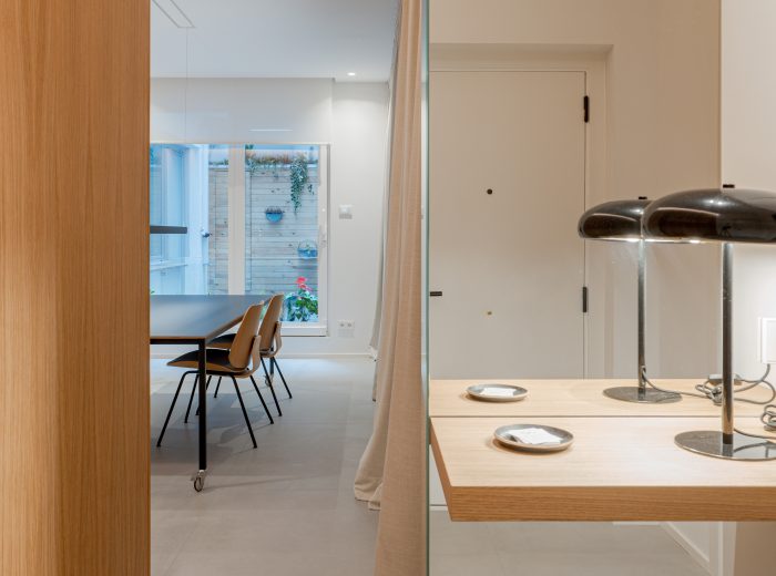 Vista de oficina desde la entrada con mueble de recibidor a medida, espejo de paño completo y repisa de madera de roble, diseño de interiores personalizado en proyecto VG66, Vitoria-Gasteiz