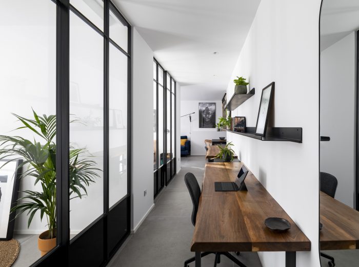 Distribuidor-estudio con gran entrada de luz natural mediante cierre acristalado de perfilería de aluminio negro, reforma integral ZB4 en Vitoria-Gasteiz.