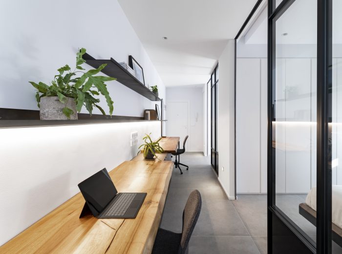 Estudio con dos puestos de trabajo y mesas a medida en madera de nogal, con baldas metálicas lacadas en negro a medida, reforma integral ZB4 en Vitoria-Gasteiz.