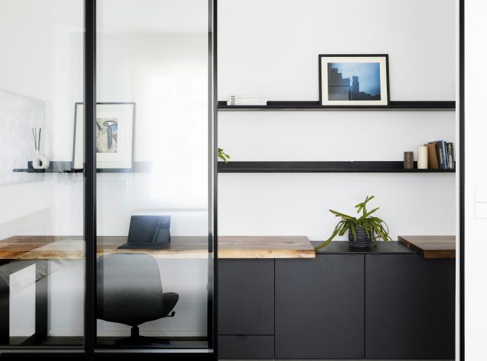 conexión visual entre dormitorio principal y distribuidor-estudio con estanterías a medida en negro y zona de almacenaje integrada, reforma integral ZB4 en Vitoria-Gasteiz.