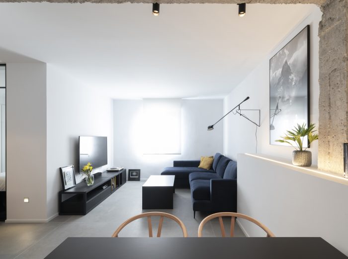 salón-comedor flexible con estructura original de hormigón visto e iluminación combinada indirecta y directa, reforma integral ZB4 en Vitoria-Gasteiz.